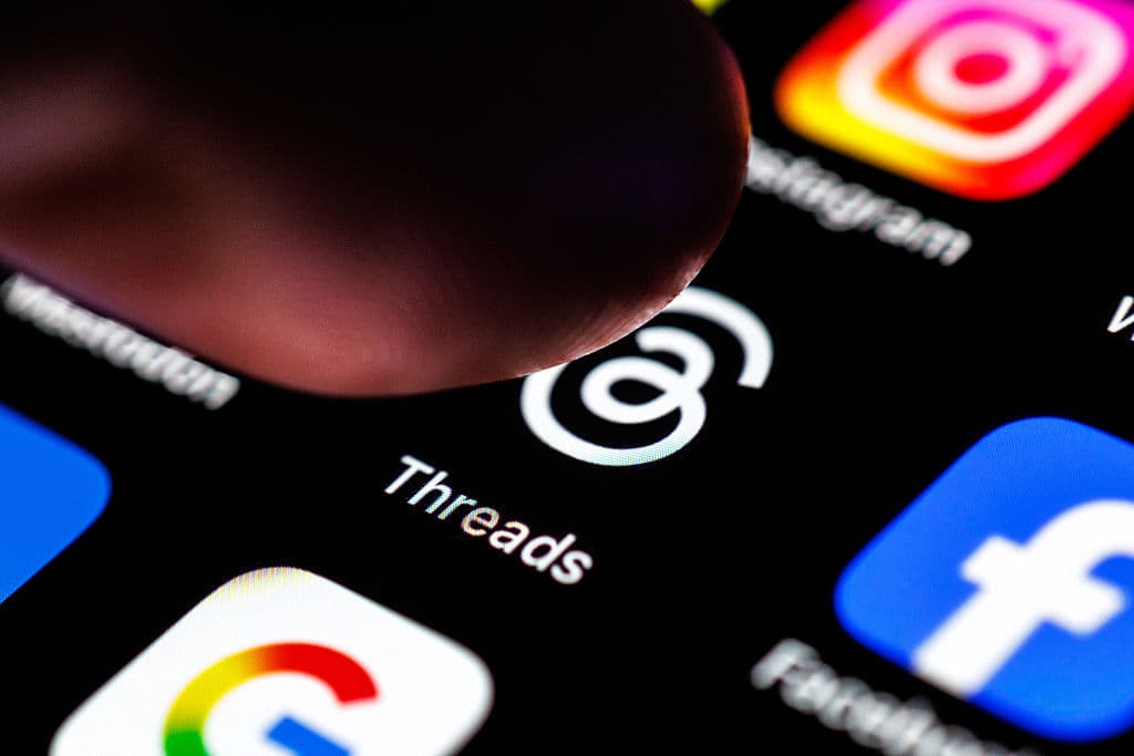 Threads-ის ლოგო და აპლიკაციის ინტერფეისი მობილურ ტელეფონში