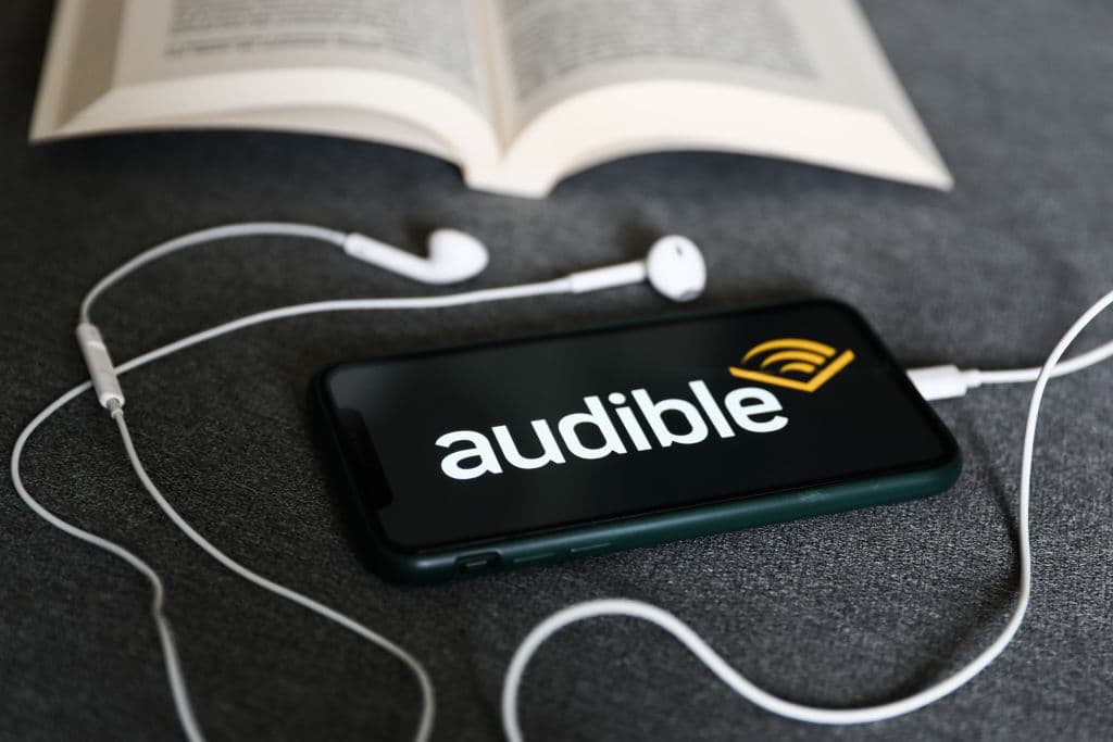 Audible-ის აპლიკაციის ლოგო და სმარტფონი აუდიოწიგნებით