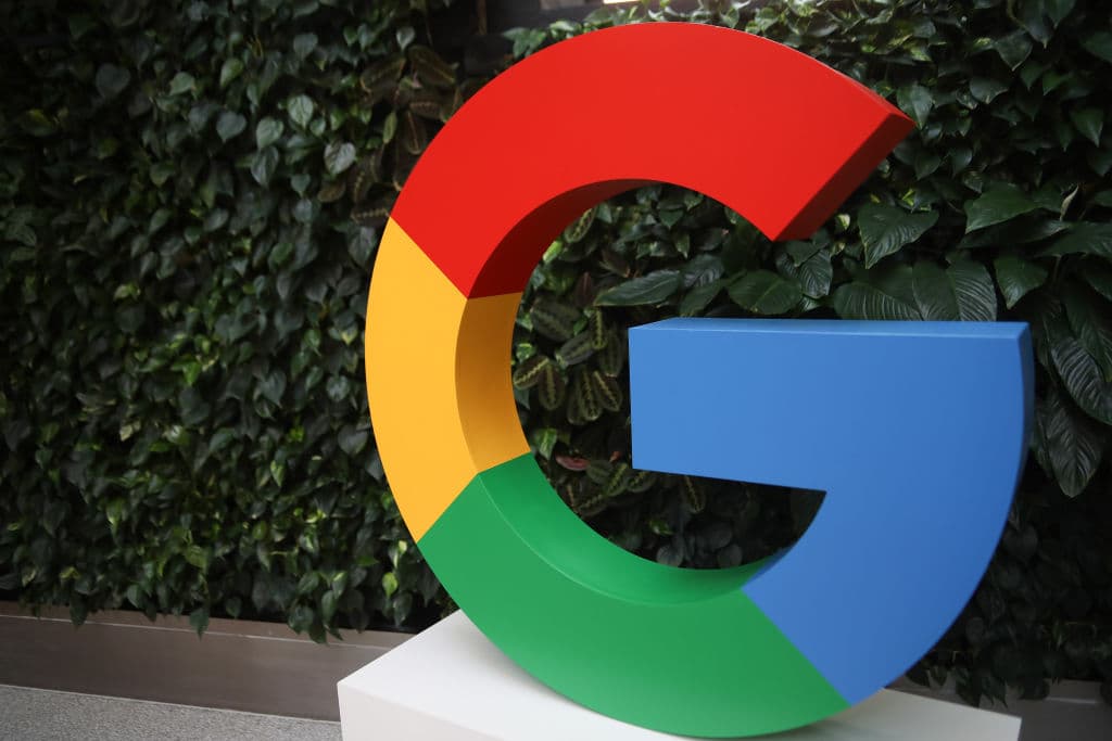 Google-ის ლოგო და სმარტფონის ეკრანი საძიებო სისტემის შედეგებით
